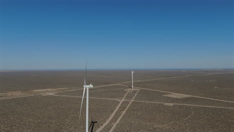 slow motion aerial view side profile two energy windmills within wind farm argentina