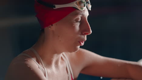 a female swimmer resting at the pool side