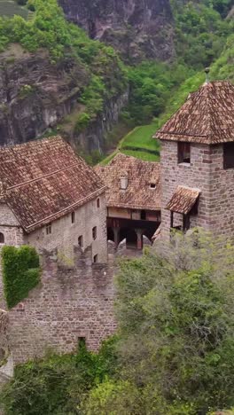 aerial tracking medieval fortress with stone walls and tiled roofs