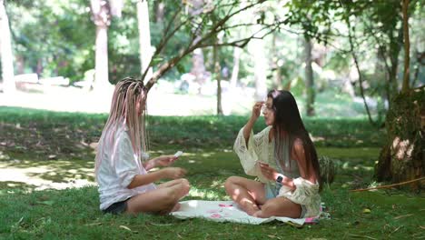 Two women playing cards in the park