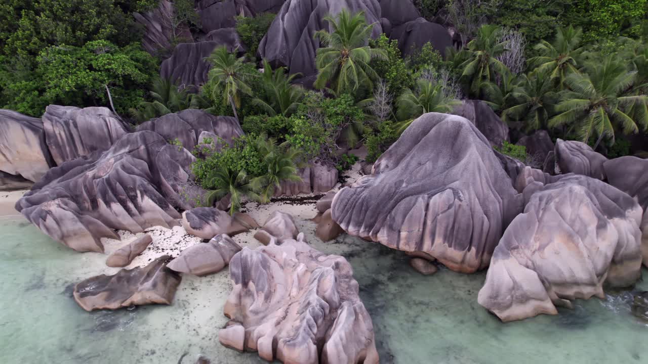 Drone berputar yang menampilkan pantai pasang surut yang spektakuler dan batu granit Anse Source d'Argent, La Digue, Seychelles 013 30fps