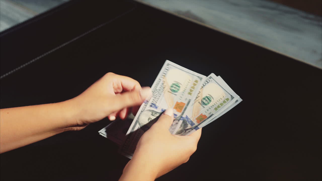 una mujer contando dólares.