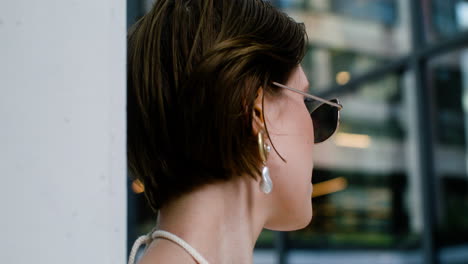 Vista-Cercana-De-Una-Mujer-Elegante-Con-Gafas-De-Sol-Y-Aretes.