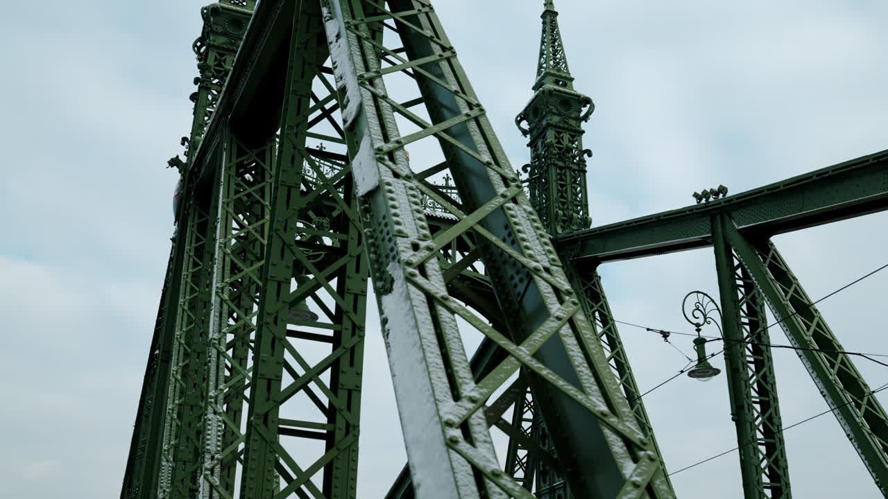 Close-up of Liberty Bridge steel framework covered with snow in Budapest, Hungary during cold winter day with historic green iron architecture detail