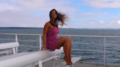 viento que sopla el cabello de una joven caucásica sentada en una tumbona - ferry de pasajeros navegando en el océano hasta la isla de north stradbroke en moreton bay, queensland, australia