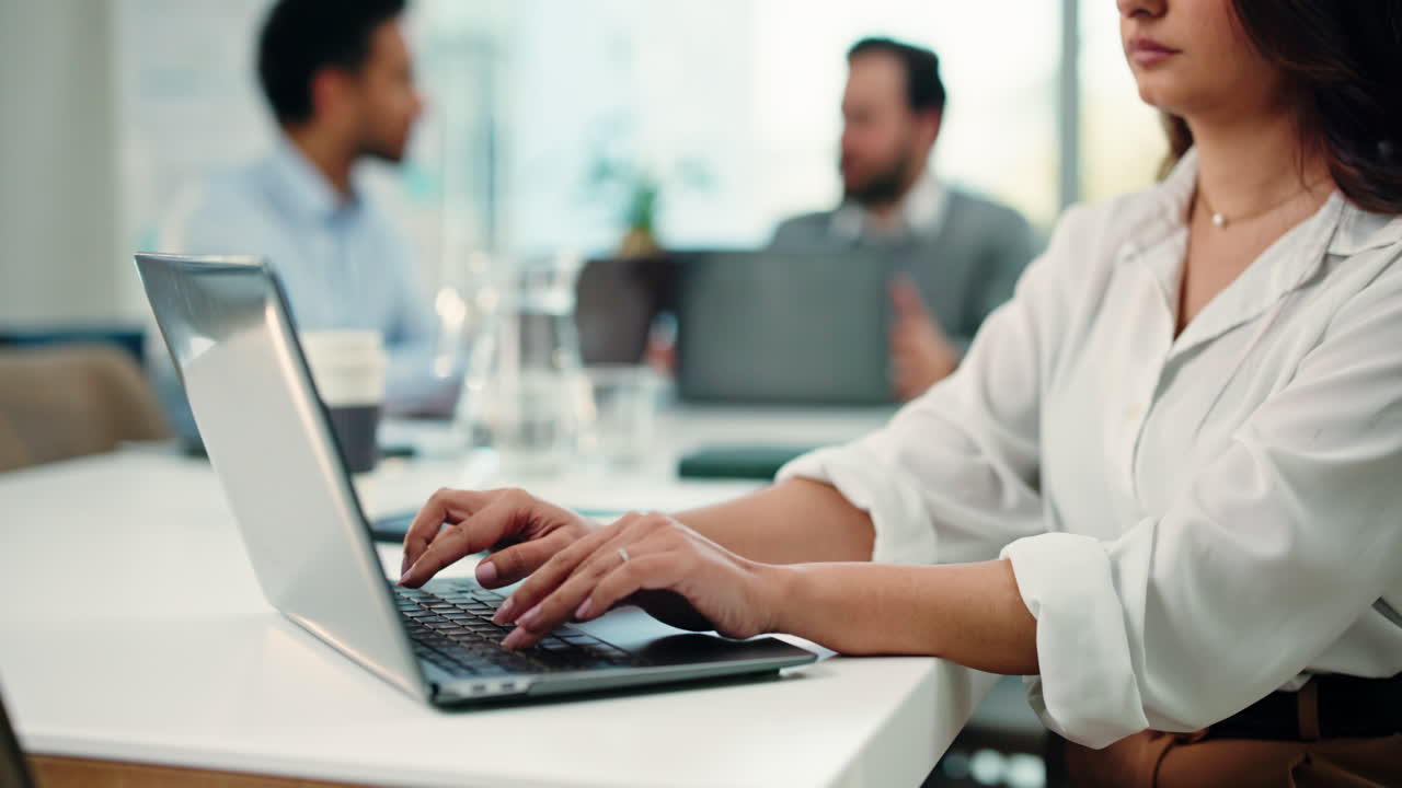 Business meeting with woman typing on laptop