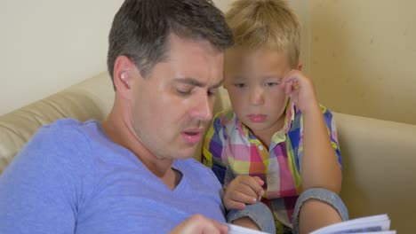 padre leyendo un libro a su hijo