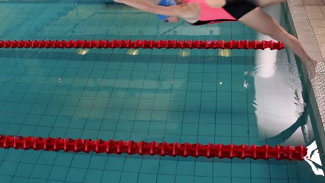 Fitte-Schwimmerin-Taucht-In-Den-Pool