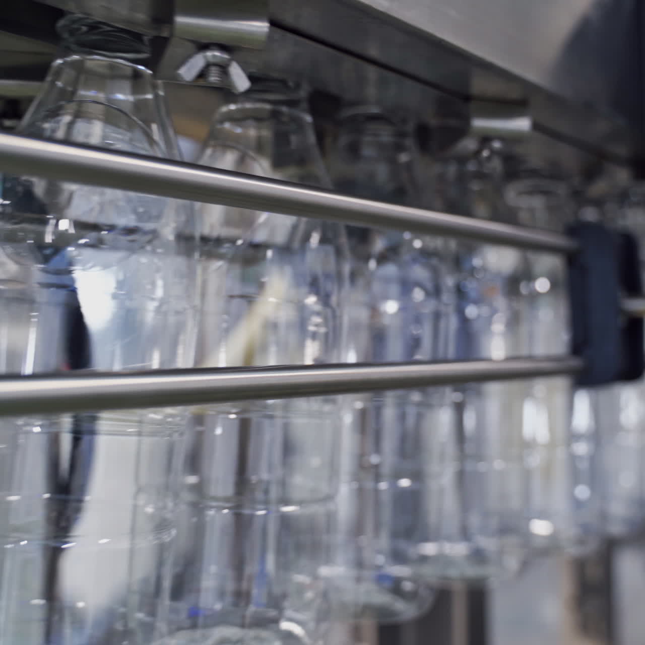 Pure transparent bottles on a conveyor belt. Conveyor with clean empty bottles at big factory. Plastic bottles moving on manufacturing line in a modernized plant.