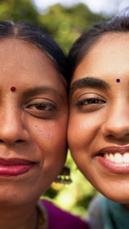 vertical video: smiling mother and daughter close-up, bonding and enjoying time together