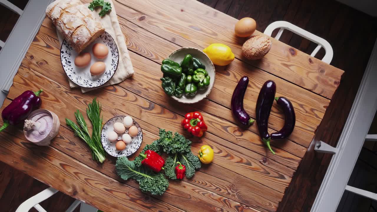 Top-down video shot of fresh vegetables and eggs on a rustic wooden table, showcasing vibrant colors