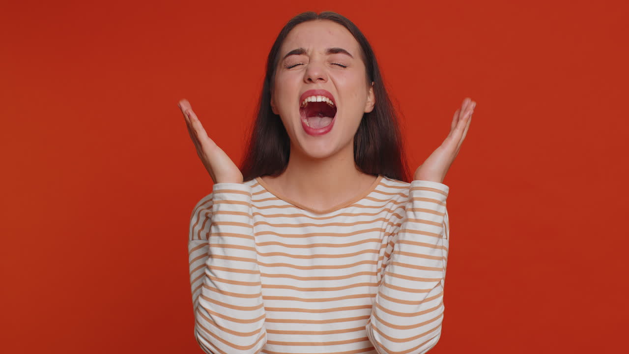 Young woman screams from stress tension problems feels horror hopelessness fear surprise shock rage