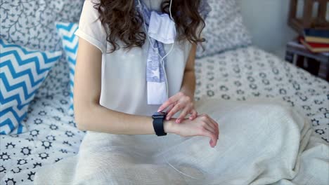 woman checking smartwatch in bed