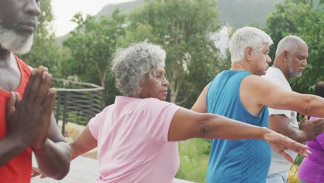 personas mayores felices y diversas practicando yoga en el jardín de una residencia de ancianos