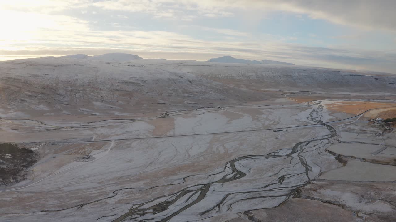 Marvelous Snow-capped Mountainside Of Westfjords Iceland With A Beautiful Sunset View - aerial shot of frozen river