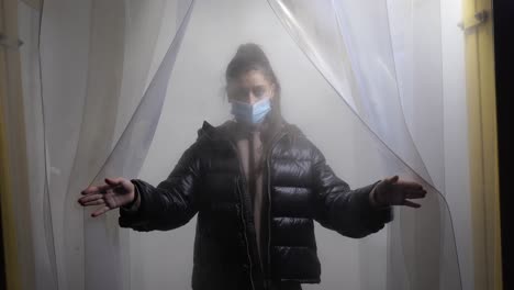 una mujer con una máscara en un espacio lleno de niebla.