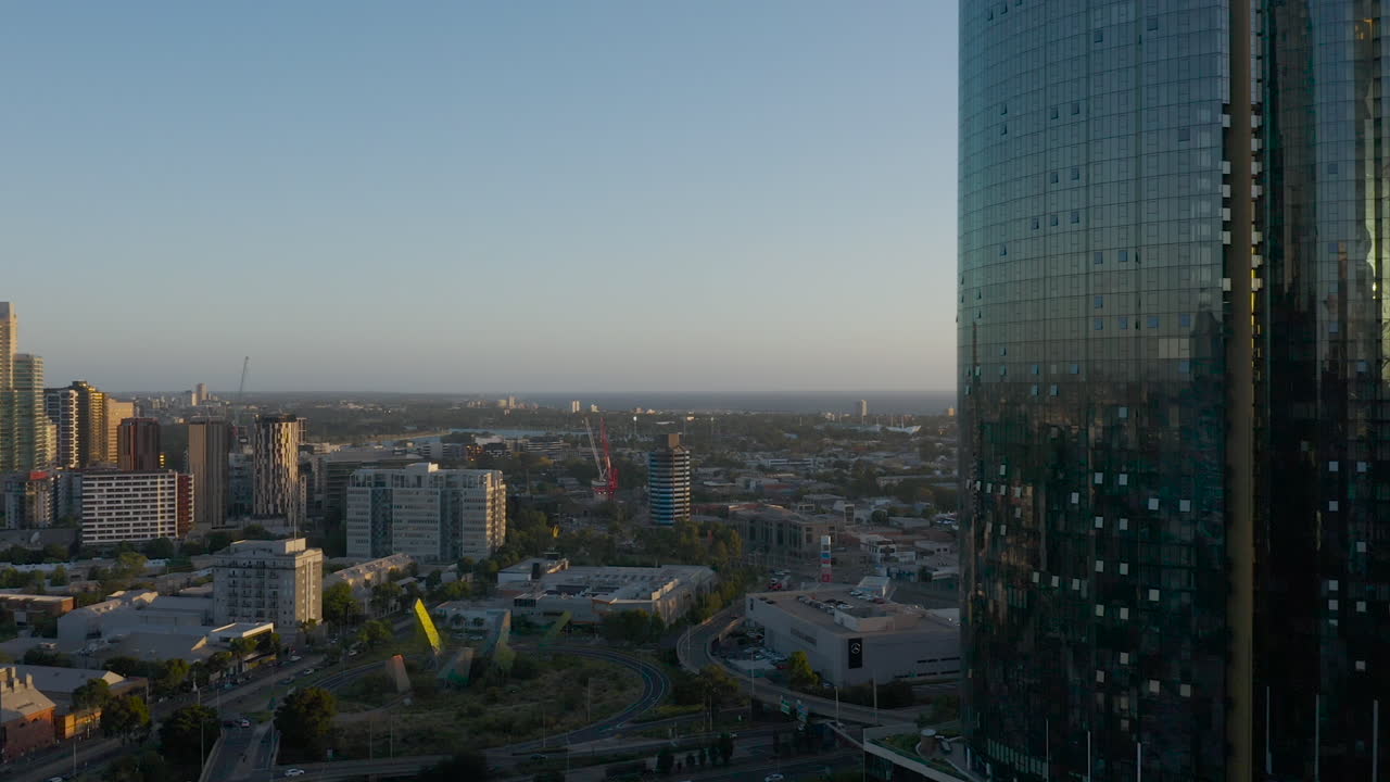 Panorâmica aérea suave sobre South Melbourne, Victoria, Austrália, observando a expansão urbana e os arranha-céus próximos à baía