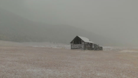 open space evergreen colorado first snow grassy field red brown horse barn aerial drone fall autumn winter blizzard snowy rocky mountain front range denver historic town circle left parallax motion