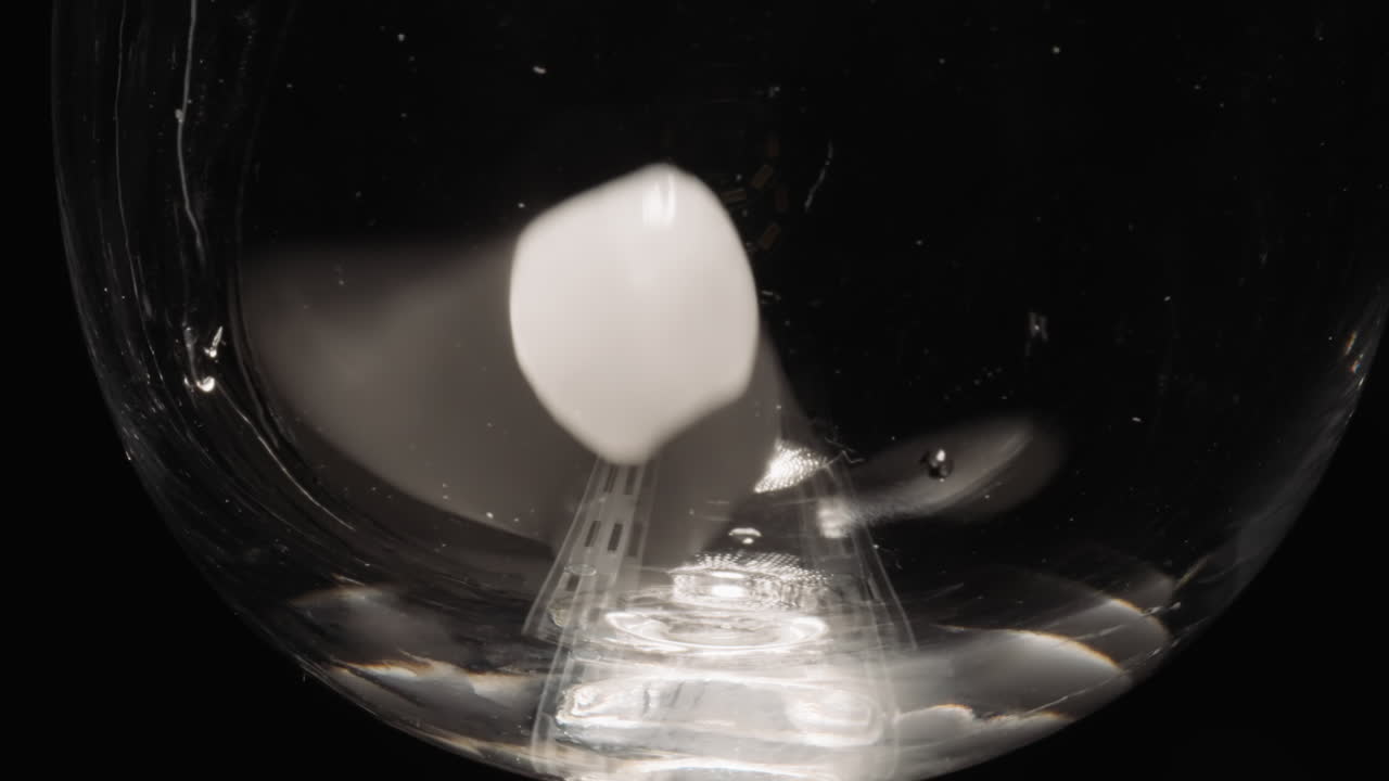 빈 유리잔에 던진 얼음 큐브가 굴러가는 측면에 부 ⁇ 히고