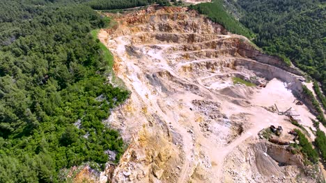 stone mine excavation on the side of the mountain destroying the forest