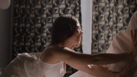 woman playing with a blanket in bed