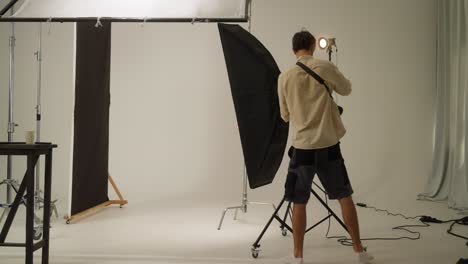 fotógrafo configurando luces y telón de fondo en un estudio fotográfico
