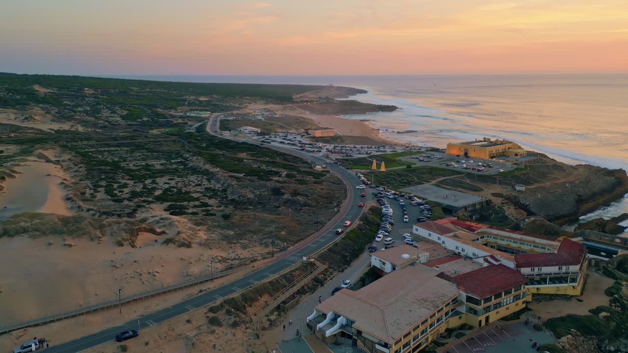 Cozy coastal resort evening twilight aerial view. Ocean waves washing coastline