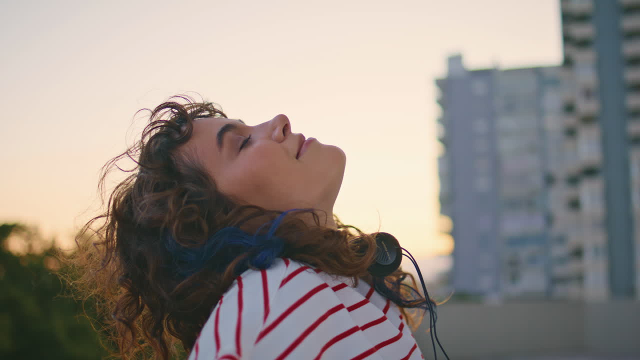 modelo urbano posando luz del sol de la noche primer plano. mujer relajada cerrando los ojos en el techo
