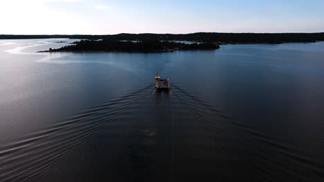 aerial view foillowing a car ferry in the archipelago of aland islands, finland