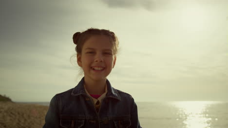 Glückliches-Lächelndes-Mädchen,-Das-Morgens-Den-Meeresstrand-Genießt.-Kind-Schaut-Kamera-Am-Ufer.