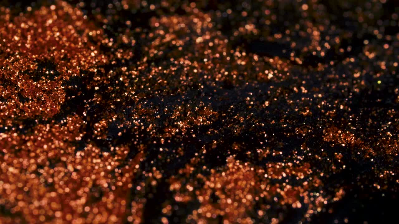 abstracto colorida arena roja dorada fluye orgánicamente en líquido colorido en macro, fondo negro