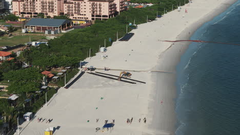 machinery at work expanding the beach of jurere in florianopolis, brazil