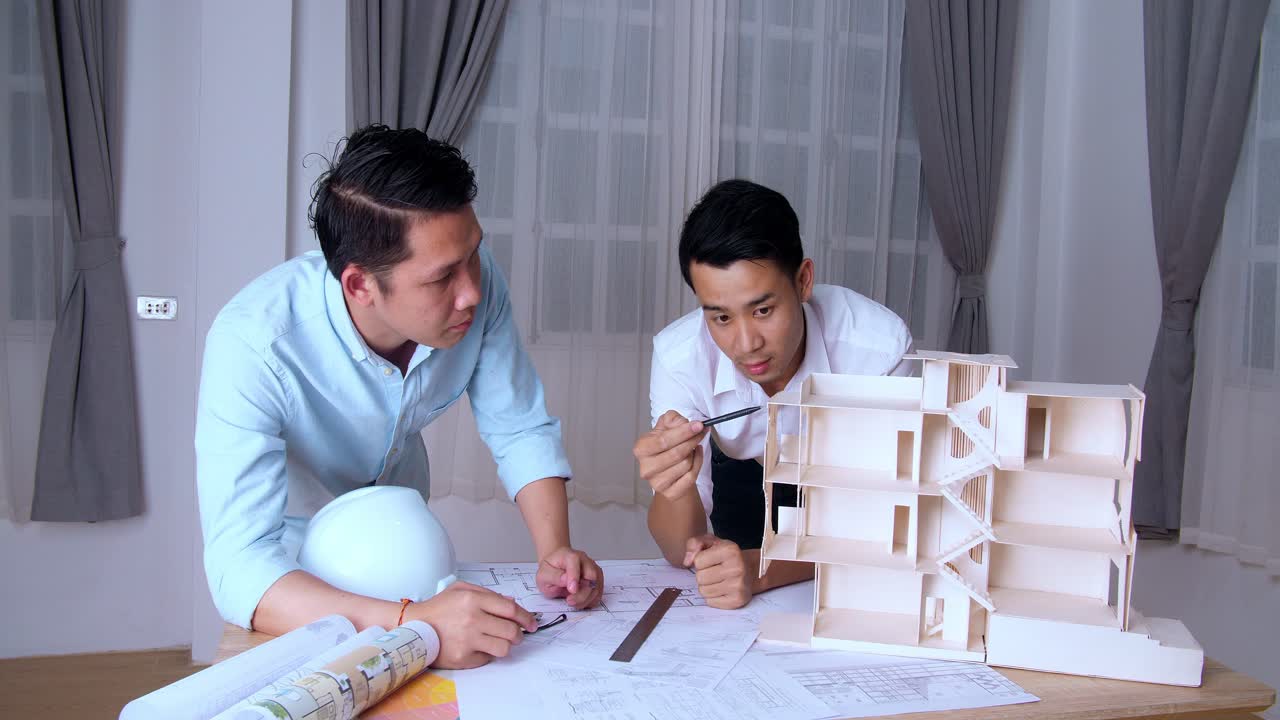 Two Young Architects Working On New Architectural House Model