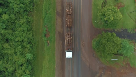 Beladener-Holztransporter,-Der-Eine-Straße-Entlang-Fährt-Und-Holz-Transportiert