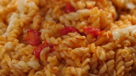 combining cooked fusilli pasta with tomato sauce made of cherry tomatoes and tomato paste