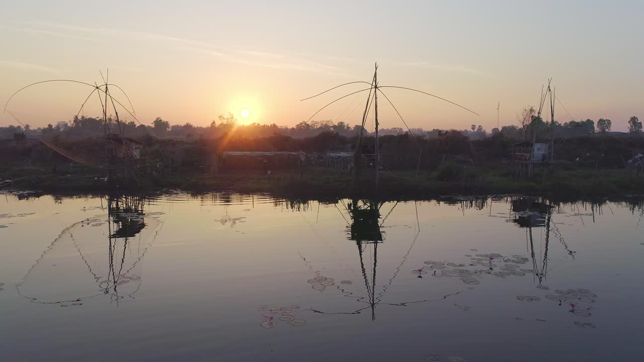 el amanecer sobre un lago sereno con redes de pesca