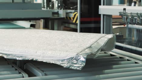 Primer-Plano-De-Una-Línea-De-Envasado-Lineal-Automatizada-De-Fábrica-Para-Productos-Textiles