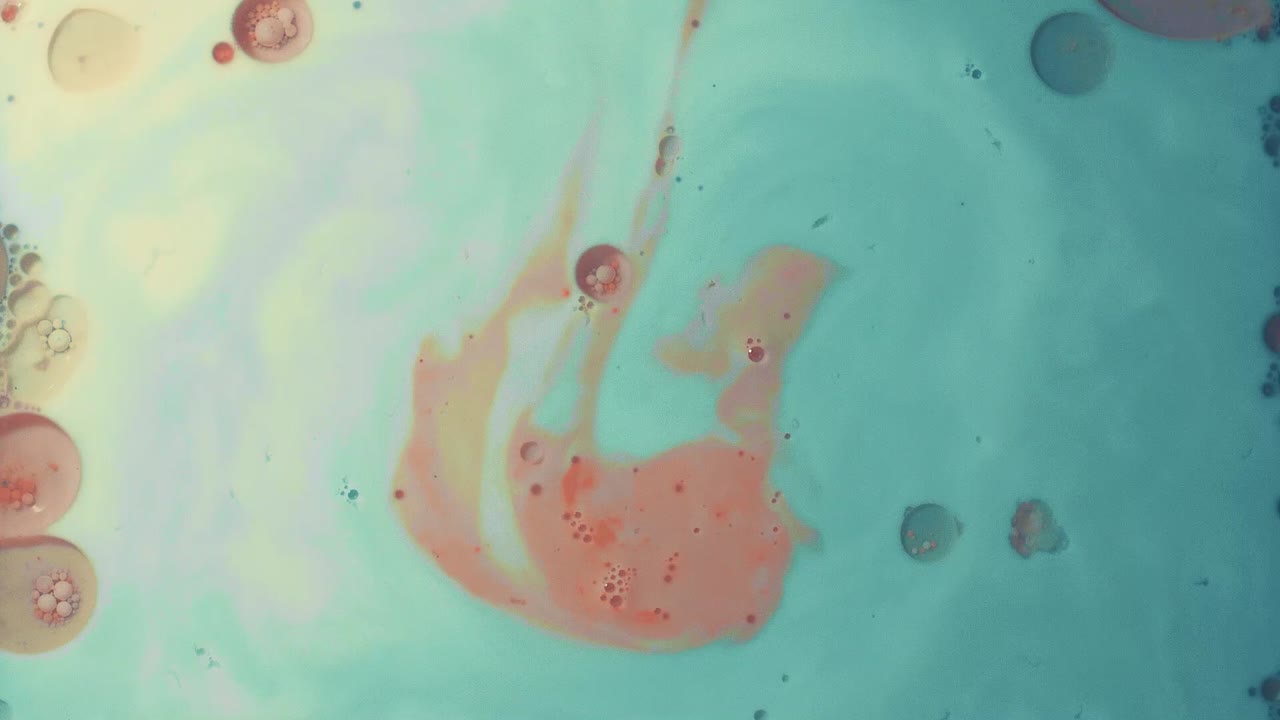 orange color drops into a sea of blue fluid art