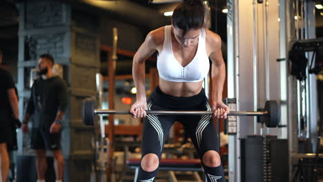 mujer levantando pesas en el gimnasio