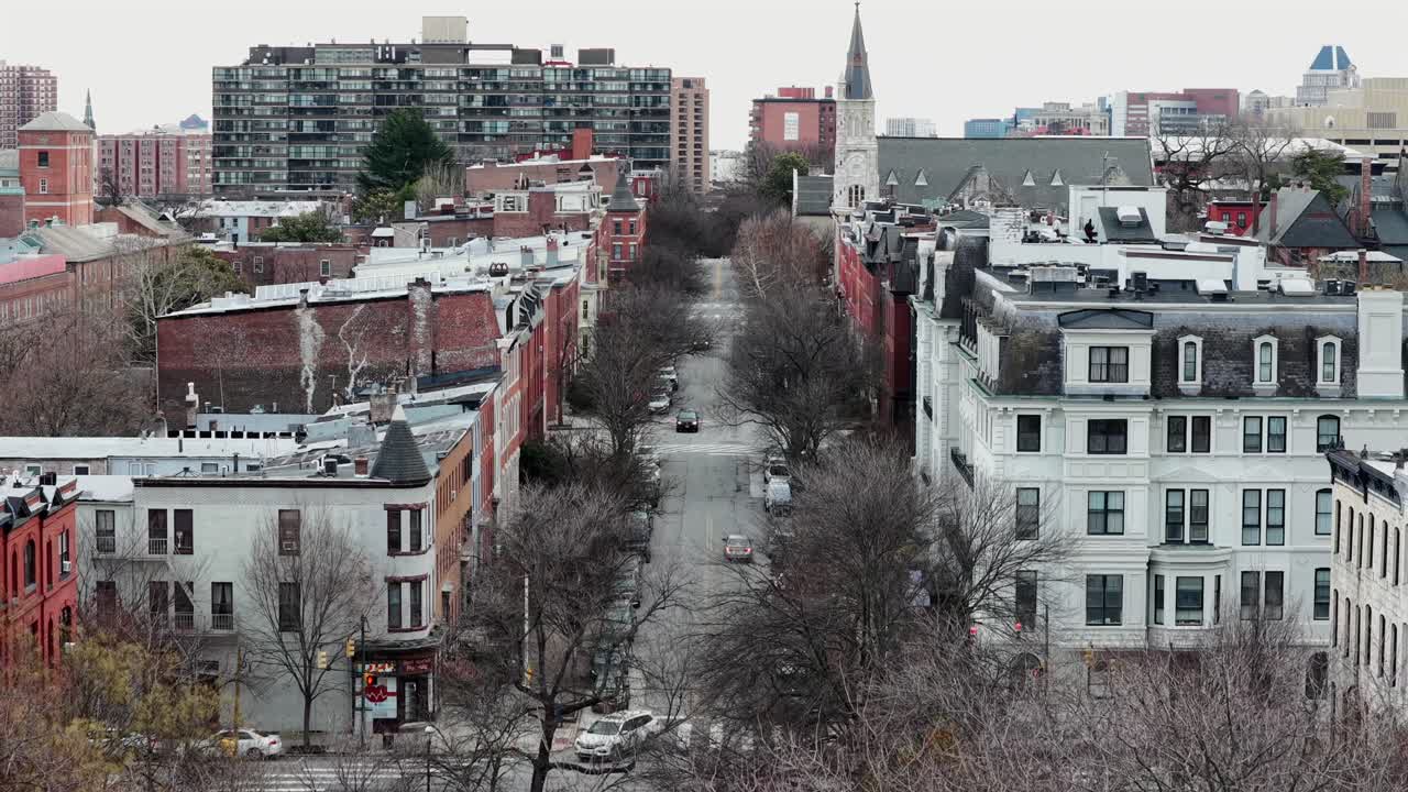 Vista aérea de una calle urbana con edificios históricos y coches en movimiento