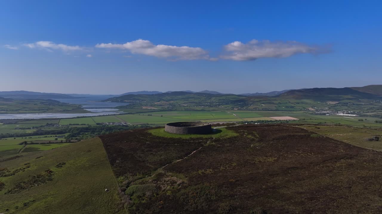 Grianan of Aileach, County Donegal, Ireland, June 2023. Drone clockwise orbit of the iconic Gaelic Stone Fort with Lough Swilly, Inch Wildfowl Reserve and Derry City Northern Ireland in the distance.