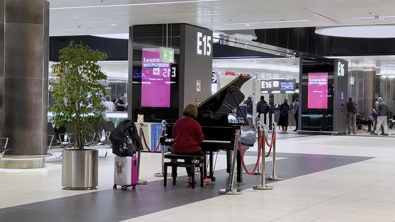 Woman Playing Piano in Airport Terminal