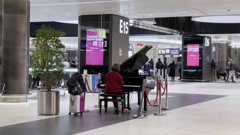 woman playing piano in airport terminal