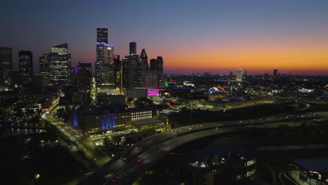 aerial rising shot panning over the i90, toward the houston skyline, dusk in usa