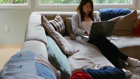 mother and son using laptop in living room 4k