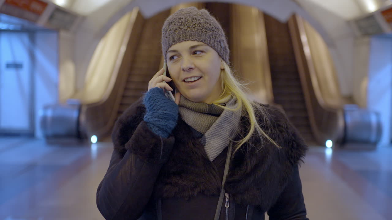 Woman talking on the phone in a subway station