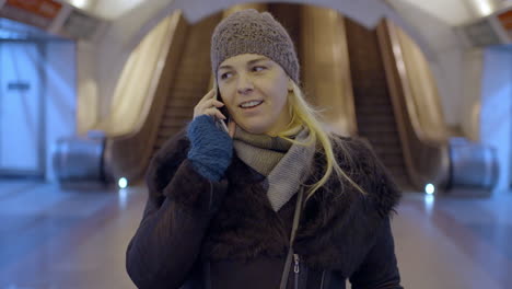 woman talking on the phone in a subway station