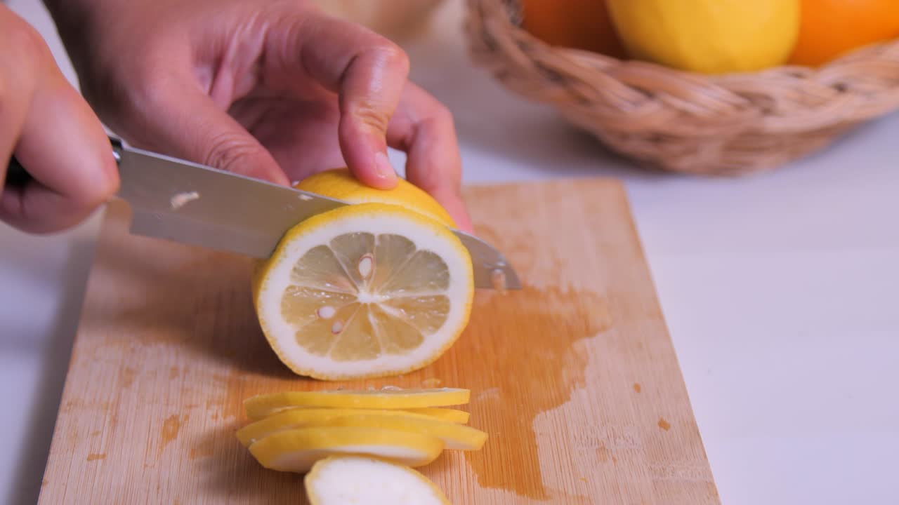 en primer plano, corta el limón en la tabla de cortar en la cocina.