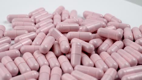 close up of the rotation soft pink pills or capsules on white background