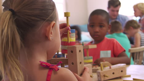 montessori school pupils work at desk with wooden building set